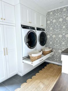 a washer and dryer in a laundry room with floral wallpaper on the walls