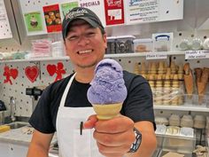 a man is holding an ice cream cone in his hand and smiling at the camera