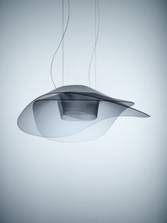 an unusual light fixture hanging from the ceiling in front of a white wall and floor