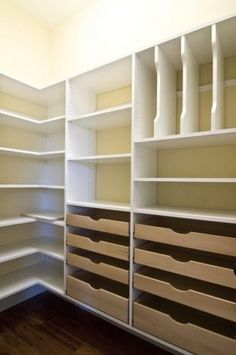 an empty walk in closet with lots of shelves