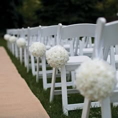 rows of white chairs lined up with flowers on the back one row is decorated with pom poms