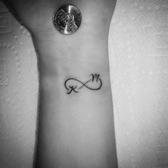 a small wrist tattoo with an infinite symbol