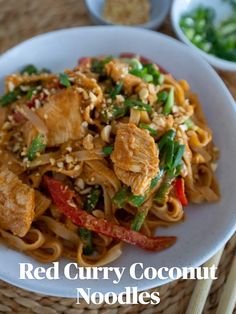 red curry coconut noodles with chicken and vegetables in a white bowl next to chopsticks