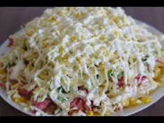 a white plate topped with shredded cheese and vegetables