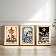 three framed posters on the wall in a room with wood flooring and white walls