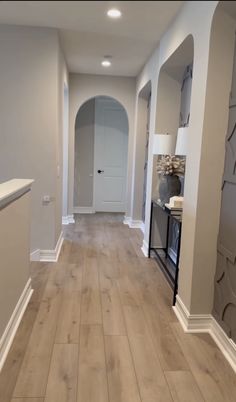 an empty hallway with white walls and wood floors