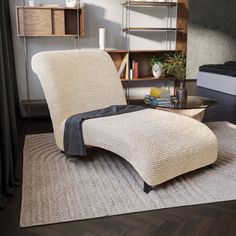 a chair and ottoman in a living room with a rug on the floor next to it