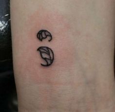 a small black and white tattoo on the ankle