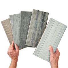 four different types of wood are being held by two hands, one is gray and the other is white