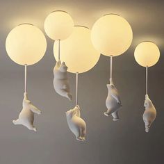 some white lights hanging from the ceiling with animals on them and balloons in the air