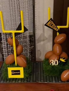 two fake footballs are on display in front of a window with the number 30