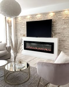 a living room with two chairs and a television mounted on the wall in front of it