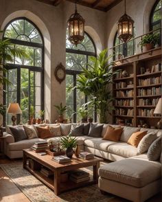 a living room filled with lots of furniture and large windows covered in bookshelves