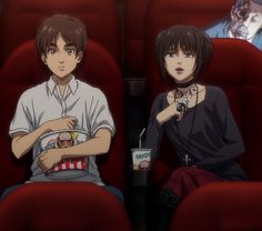 two people sitting in red chairs eating food and drinking soda while looking at each other