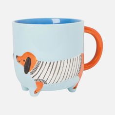 a blue mug with an orange handle and a dachshund design on it