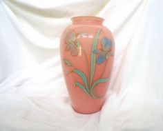 a pink vase with flowers painted on it