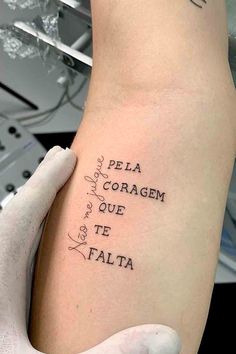 a person with a tattoo on their arm that says, pela coragem que te