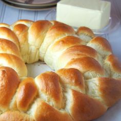 a large braided bread is sitting on a table next to butter and knifes