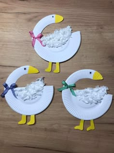 three paper plates shaped like ducks on a wooden table