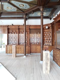 an empty room with wood paneling and painted ceiling, along with wooden cabinets on both sides