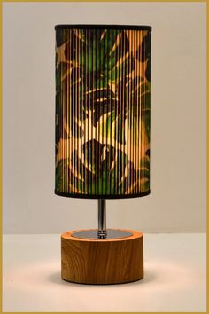 a lamp that is sitting on top of a wooden base and has a tiger print shade