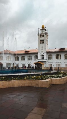 a large white building with a fountain in front of it