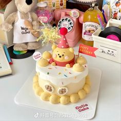 a winnie the pooh birthday cake on a table with other toys and gifts around it