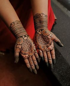 a woman's hands with henna tattoos on them