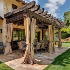 an outdoor patio covered with curtains and furniture