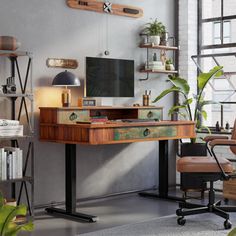 a desk with a computer on it in front of a window and some bookshelves