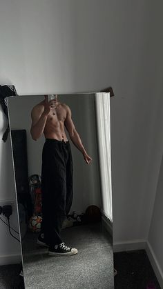 a man standing in front of a mirror taking a selfie