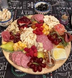 a large platter of meats, cheeses and fruit