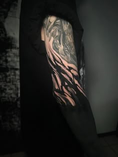 a man's arm covered in black and grey ink with an animal design on it