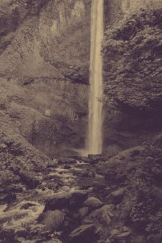 an old photo of a waterfall in the mountains