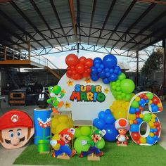 an outdoor birthday party with balloons and mario