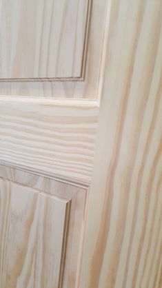 a close up view of a door handle on a wooden door with white woodgrain