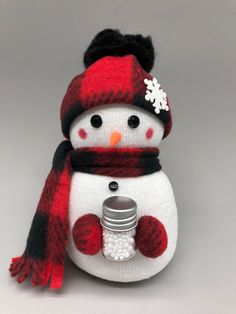 a knitted snowman with a red and black scarf around it's neck