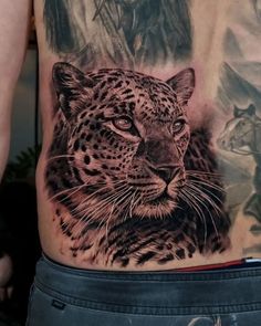 a man with a tattoo on his stomach has an image of a leopard and other animals