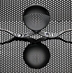 an abstract black and white photo with circles in the center, reflecting on top of it