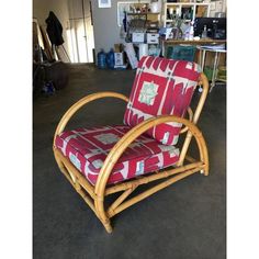 a bamboo chair with red and white patterned upholstered seat cushion on the floor