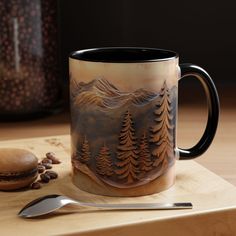 a coffee mug sitting on top of a wooden table next to a spoon and fork