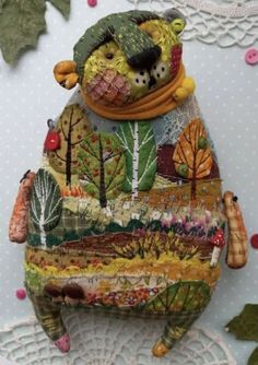 an animal made out of fabric sitting on top of a doily covered tablecloth