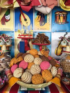 an assortment of cookies and pastries displayed on a table in front of colorful posters