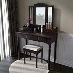 a dressing table with mirror and stool in a room