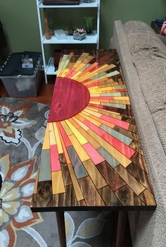 a coffee table made out of stained wood with an abstract design on it, sitting in the middle of a living room