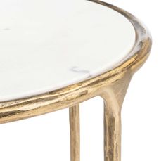 a white marble topped table with gold trimmings on the top and bottom, against a white background