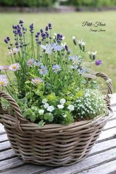 a basket filled with flowers sitting on top of a wooden table