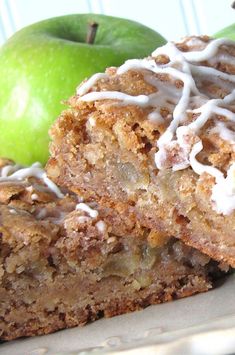 two pieces of apple pie sitting on top of a white plate next to an green apple