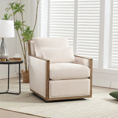 a living room with white shutters and a chair