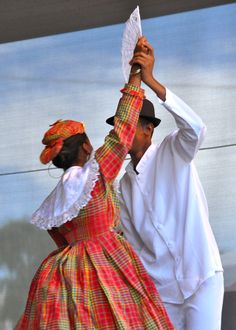 a man and woman dancing on stage with their hands in the air